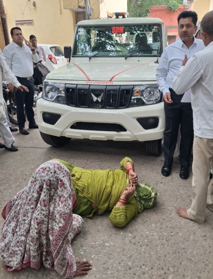 भूमि पैमाइश विवाद पर किसानों का धरना, एसडीएम की गाड़ी के आगे सड़क पर लेटीं महिलाएं :